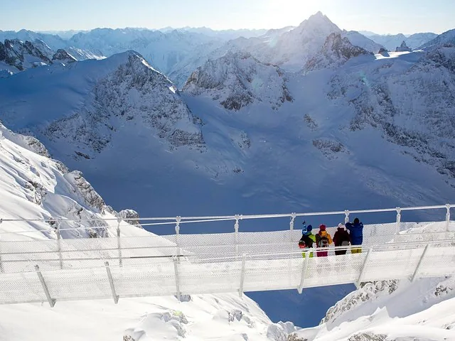 Group of people on the Titlis Cliff Walk overlooking snowy mountain peaks