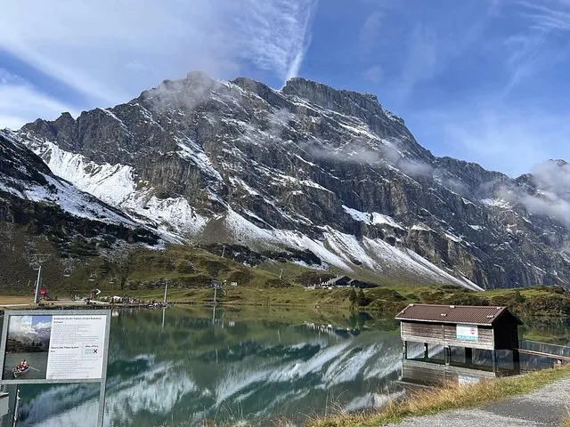 Trübsee lake reflecting the surrounding majestic mountains on a clear day