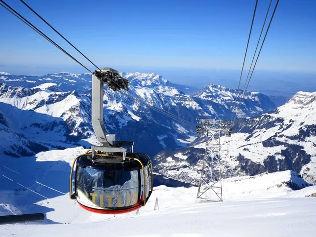 A Titlis cable car descending towards the valley and distant mountains