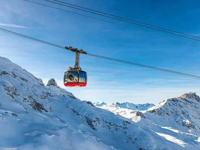 A Titlis Rotair cable car ascending above snow-covered mountains