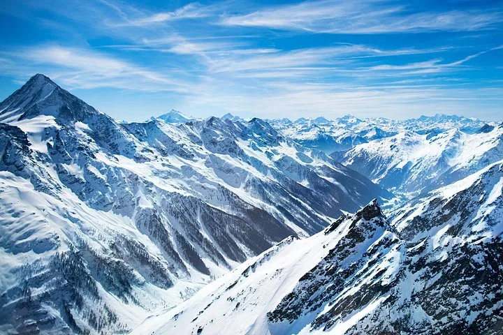 A group of people standing on the Titlis Cliff Walk overlooking mountains