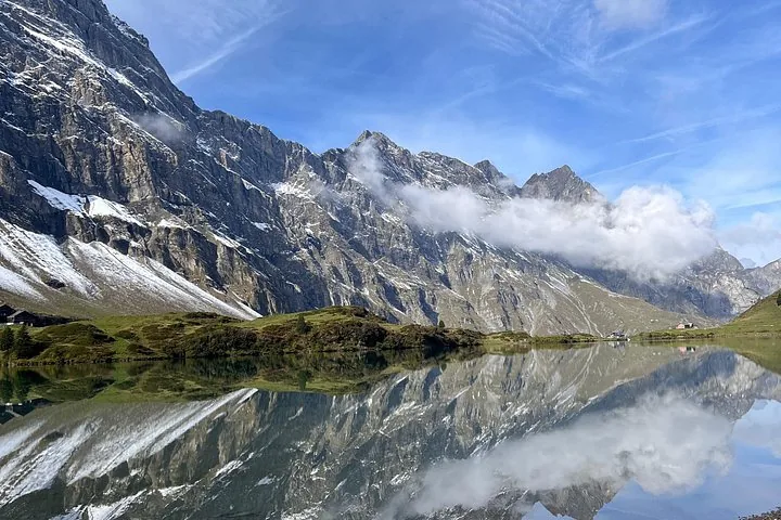 Stunning reflection of rocky mountains and clouds in Trübsee alpine lake
